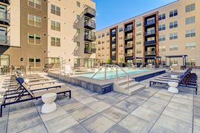 Lone Tree apartment for rent - A large outdoor pool area with sun loungers and a small waterfall.