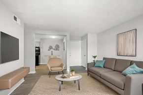 Hendersonville apartment for rent - A living room with a grey couch, a brown chair, and a brown bench.