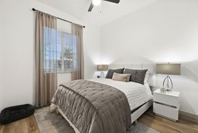 Goodyear apartment for rent - A bedroom with a large bed and a window with curtains.