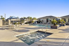 Goodyear apartment for rent - A pool area with a hot tub and lounge chairs.