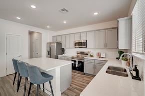 Phoenix townhouse for rent - A modern kitchen with a white island and grey chairs.