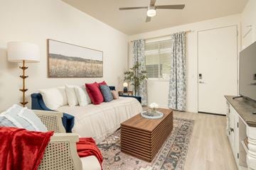 Glendale apartment for rent - A living room with a white couch, a red blanket, and a painting on the wall.