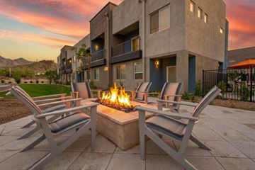 Phoenix apartment for rent - A fire pit sits between two chairs in front of a building.