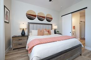 Tucson apartment for rent - A bedroom with a large bed and a wooden nightstand.