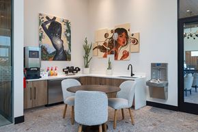 Tucson apartment for rent - A modern kitchen with a table and chairs and two paintings on the wall.