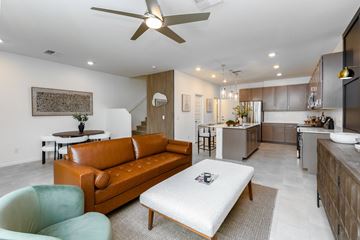 Apache Junction townhouse for rent - A modern living room with a brown leather couch and a white ottoman.
