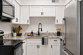 Hendersonville apartment for rent - A kitchen with white cabinets and a black stove top oven.