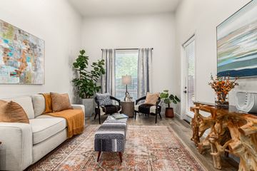 Scottsdale apartment for rent - A living room with a white couch, a wooden coffee table, and a large painting on the wall.