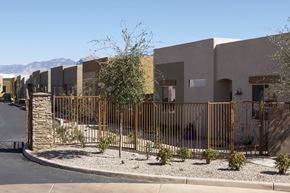 Tucson apartment for rent - A row of houses with a metal fence in front.