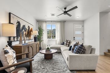 Goodyear apartment for rent - A living room with a grey sofa, a wooden cabinet, a coffee table, and a painting on the wall.