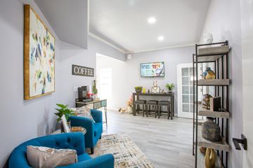Green Valley apartment for rent - A living room with a blue couch and a coffee sign on the wall.