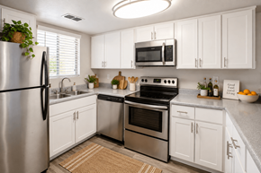 Tucson townhouse for rent - A kitchen with white cabinets and stainless steel appliances.