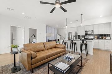 San Tan Valley apartment for rent - A living room with a brown leather couch and a ceiling fan.