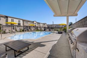 Phoenix townhouse for rent - A pool area with a bench and a building in the background.