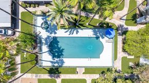 Green Valley apartment for rent - A swimming pool surrounded by palm trees and a white fence.