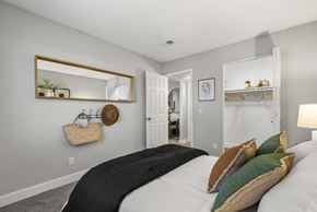 Tucson apartment for rent - A bedroom with a large bed and a mirror on the wall.