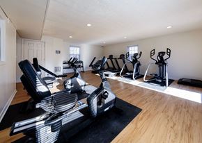 Lexington apartment for rent - A home gym with a row of treadmills and elliptical machines.