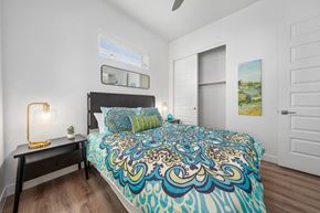 Surprise apartment for rent - A bedroom with a bed, a nightstand with a lamp, and a painting on the wall.