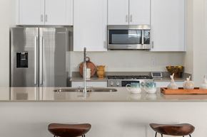 Surprise apartment for rent - A modern kitchen with a stainless steel refrigerator and a microwave above the stove.