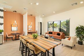 Peoria apartment for rent - A modern dining room with a long wooden table and chairs.