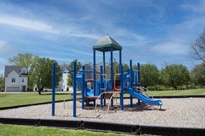 Hendersonville apartment for rent - A playground with a blue slide and a green roofed structure.
