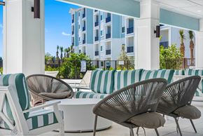 Ft. Myers apartment for rent - A white and green striped sofa sits in front of a building.