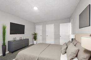 Hendersonville apartment for rent - A bedroom with a large bed and a flat screen TV mounted on the wall.