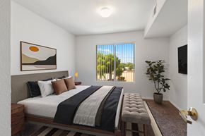 Kingman apartment for rent - A bedroom with a large bed and a painting on the wall.
