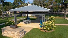 Lexington apartment for rent - A gazebo with a stone pillar and a fireplace is surrounded by a lawn and trees.