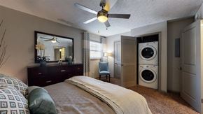 Lexington apartment for rent - A bedroom with a bed, a dresser, a mirror, and a washing machine.