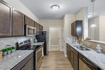 Leland apartment for rent - A kitchen with dark brown cabinets and granite countertops.