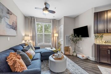 Charlotte apartment for rent - A living room with a blue couch and a ceiling fan.