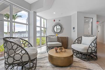 Naples apartment for rent - A living room with a white chair and a gold coffee table.