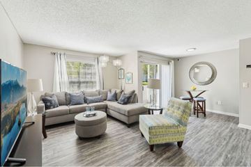 Tampa apartment for rent - A living room with a sofa, a chair, and a painting on the wall.
