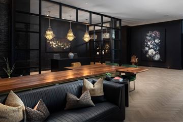 Denver apartment for rent - A modern living room with a black couch and a wooden table.