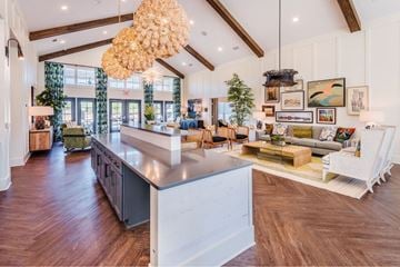 Leland apartment for rent - A modern kitchen with a large island and a dining area with a table set for four.