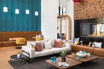 Aurora apartment for rent - A modern living room with a white sofa and a wooden coffee table.