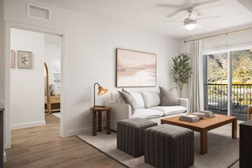 Glenwood Springs apartment for rent - A living room with a white sofa, a wooden coffee table, and a painting on the wall.