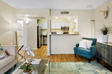 Tucson apartment for rent - A living room with a blue couch and a coffee table.