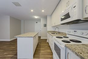 Toronto apartment for rent - a kitchen with white appliances and granite counter tops and white cabinets at 107 Redpath, Canada
