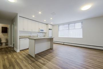 Toronto apartment for rent - A kitchen with white cabinets and a wooden floor.