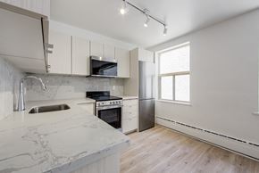 East York apartment for rent - a kitchen with marble counter tops and white cabinets at 111 Cosburn, East York