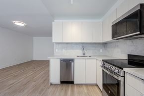 East York apartment for rent - an empty kitchen with white cabinets and stainless steel appliances at 111 Cosburn, East York Ontario