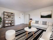 Scarborough apartment for rent - A living room with a white couch, a black and white striped rug, and a wooden coffee table at Queen St East in Scarborough, ON