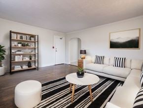 Scarborough apartment for rent - A living room with a white couch, a black and white striped rug, and a wooden coffee table at Queen St East in Scarborough, ON