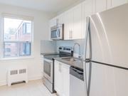 Scarborough apartment for rent - A white kitchen with a black fridge and stove at Queen St East in Scarborough, ON