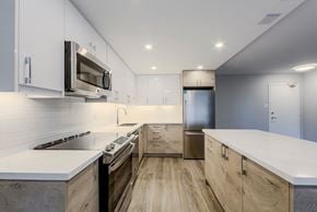 Mississauga apartment for rent - a modern kitchen with white counter tops and stainless steel appliances at 70 Park, Canada, L5G 1M5