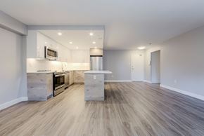 Mississauga apartment for rent - an empty living room with a kitchen with stainless steel appliances at 70 Park, Mississauga, CA, L5G 1M5