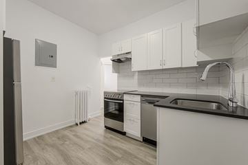 Toronto apartment for rent - A modern kitchen with white cabinets and stainless steel appliances.