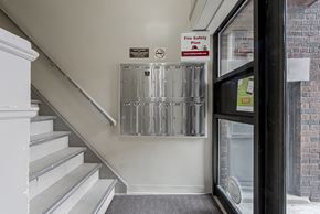 Toronto apartment for rent - an empty stairwell with a door to a building with mailboxes on the stairs at 723 Bloor Apartments, Toronto, CA